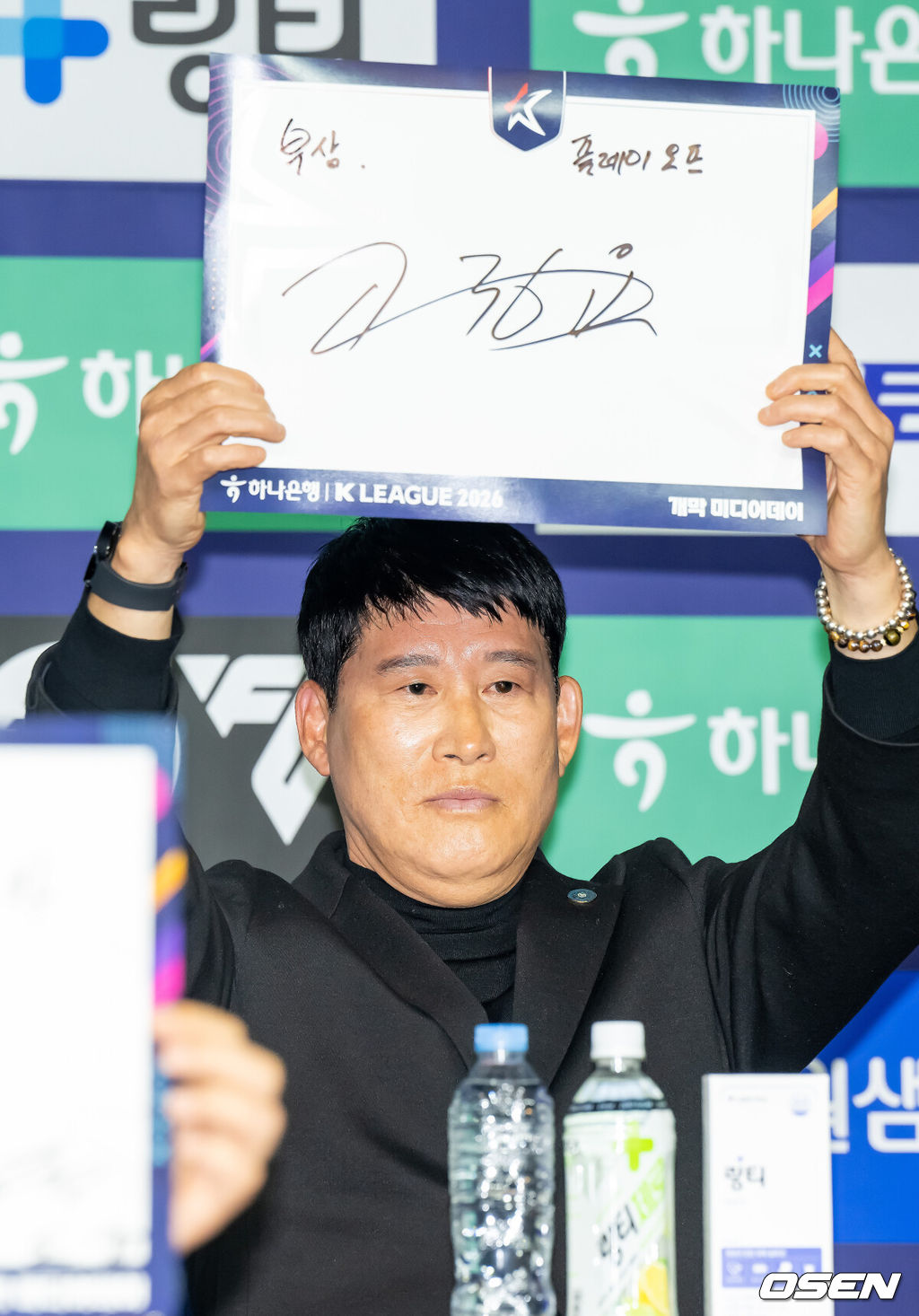 25일 서울 서대문구 스위스그랜드 호텔 컨벤션센터에서 하나은행 K리그 2026 개막 미디어데이(2부 K리그2)가 진행됐다.프로축구 K리그 29개 구단이 새 시즌 개막을 앞두고 저마다 당찬 출사표를 던졌다. 출사표를 적어달라는 사회자의 요청에 김포 고정운 감독이 자신의 이름을 들어보이고 있다. 2026.02.25 / soul1014@osen.co.kr