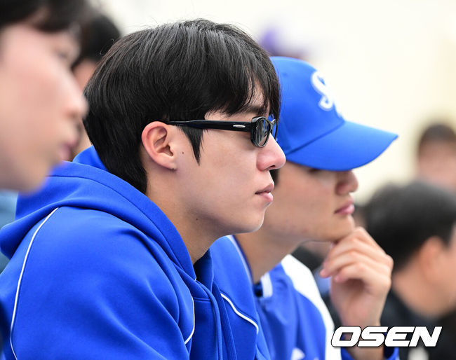 [OSEN=오키나와(일본), 최규한 기자] 2026 WBC(월드베이스볼클래식)를 준비하는 대한민국 야구 대표팀이 20일 오후 일본 오키나와 온나손 아카마 구장에서 프로야구 삼성 라이온즈와 연습경기를 펼쳤다. 야구 대표팀은 오키나와에서 국내 팀들과 6차례 연습경기를 치르며 전력을 끌어올릴 예정이다.삼성 원태인이 관중석에서 대표팀의 경기를 주시하고 있다. 2026.02.20 / dreamer@osen.co.kr