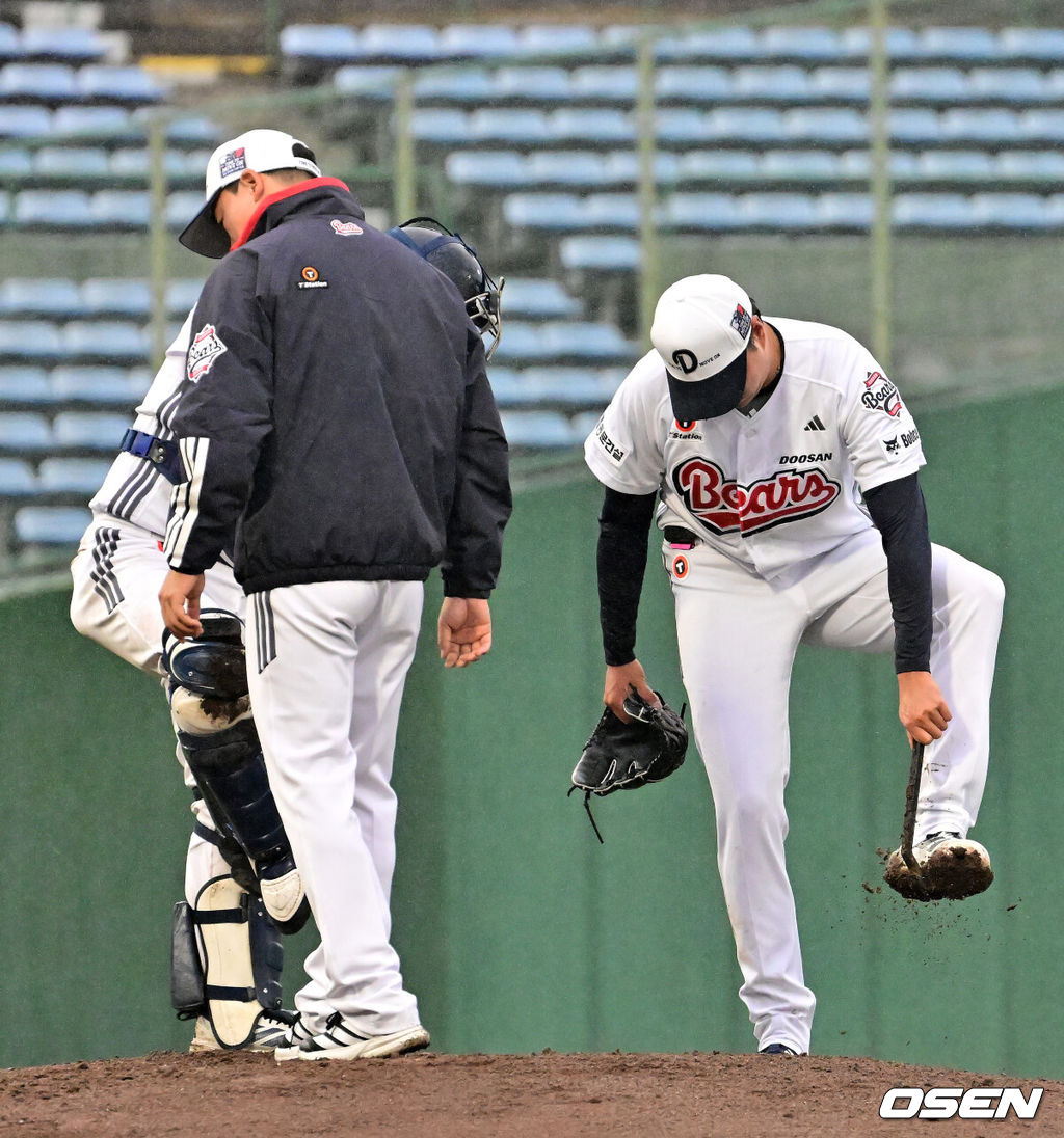 26일 일본 미야자키 산마린 스타디움에서 두산 베어스와 롯데 자이언츠의 구춘대회 경기가 열렸다.두 팀의 맞대결은 롯데가 6-2로 앞선 3회말 악천후로 인해 노게임 선언됐다. 3회초 두산 이영하가 계속 내리는 비에 스파이크에 묻은 흙을 털어내고 있다. 2026.02.26 /jpnews@osen.co.kr