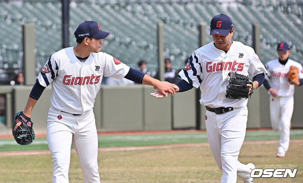 12일 부산 사직야구장에서 2026 신한 SOL KBO 리그 롯데 자이언츠와 KT 위즈의 시범경기가 열렸다. 이날 부산 사직과 이천, 대전, 광주, 마산 5개구장에서 막을 올렸다.롯데 자이언츠 손호영이 2회초 2사 KT 위즈 이강민의 3루 땅볼을 어렵게 잡아 아웃시키고 김진욱과 하이파이브를 하고 있다. 2026.03.12 / foto0307@osen.co.kr