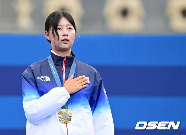 [OSEN=파리(프랑스), 최규한 기자] 임시현(21)이 남수현(19)을 꺾고 금메달을 목에 걸었다. 남수현은 은메달을 차지했다.&nbsp;임시현은 3일(한국시간)&nbsp;프랑스&nbsp;파리&nbsp;래쟁발리드에서 열린&nbsp;2024&nbsp;파리 올림픽 양궁 여자 개인 결승전에서 남수현과 겨뤄 7-3으로 승리했다. 이로써 한국은 양궁 여자 개인 결승에서 금메달과 은메달을 획득했다. 동메달은 전훈영(30)을 꺾은 리사 바르블랭(프랑스)이 차지했다.임시현이 시상대에서 애국가를 부르고 있다. 2024.08.03 / dreamer@osen.co.kr
