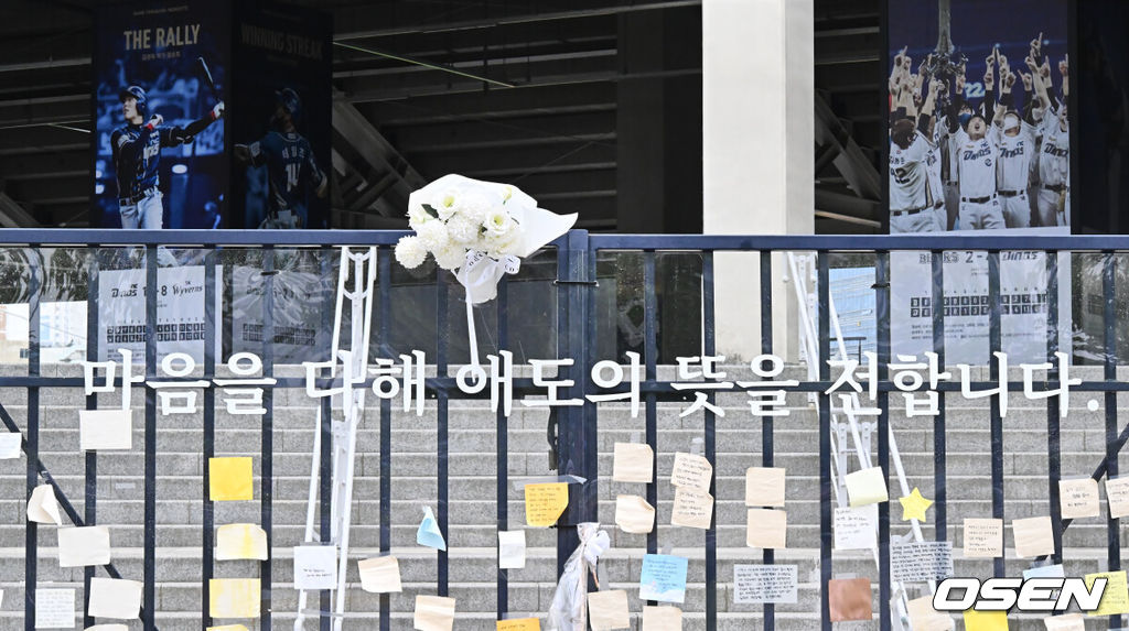 지난 3월 29일 NC 다이노스와 LG 트윈스의 경기 중 3루 내야석 매점 부근 약 4층 높이에 있던 알루미늄 '루버'가 떨어져 관중이 사망하는 사고가 발생했다. 지난 8일 KBO는 NC 다이노스 구단의 요청에 따라, NC가 울산 문수야구장을 2025 시즌 임시 대체 홈구장으로 사용하는 것을 승인했다. 구조물 추락 사고로 여성 관중이 사망했던 창원NC파크 마산구장에 시민들이 추모하며 갖다 놓은 조화와 추모글이 빼곡히 놓여 있다. 2025.05.11 / foto0307@osen.co.kr