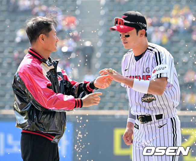 [OSEN=잠실, 지형준 기자] 28일 서울 잠실야구장에서 2026 신한 SOL KBO리그 개막전 LG 트윈스와 KT 위즈의 경기가 열렸다. 이날 LG는 요니 치리노스, KT는 맷 사우어를 선발로 내세웠다.LG 박해민이 김인석 대표이사에게 통합우승 반지를 전달받고 있다. 2026.03.28&nbsp;/ jpnews@osen.co.kr