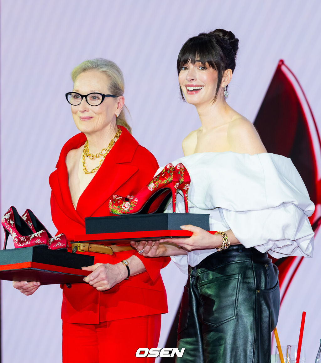 8일 오전 서울 종로구 포시즌스 호텔 서울에서 영화 '악마는 프라다를 입는다 2' 내한 기자간담회가 열렸다.'악마는 프라다를 입는다 2'는 전설적인 패션 매거진 '런웨이'의 편집장 미란다(메릴 스트립 분)와 20년 만에 기획 에디터로 돌아온 앤디(앤 해서웨이 분)가 럭셔리 브랜드의 임원이 된 에밀리(에밀리 블런트 분)와 재회하고, 완전히 달라진 미디어 환경 속에서 다시 한번 패션계의 주도권을 잡기 위해 모든 커리어를 거는 이야기다. 오는 29일 전 세계 최초 개봉.배우 메릴 스트립, 앤 해서웨이가 기자간담회에서 꽃신 스타일의 하이힐 선물을 받고 감동하고 있다. 2026.04.08/rumi@osen.co.kr