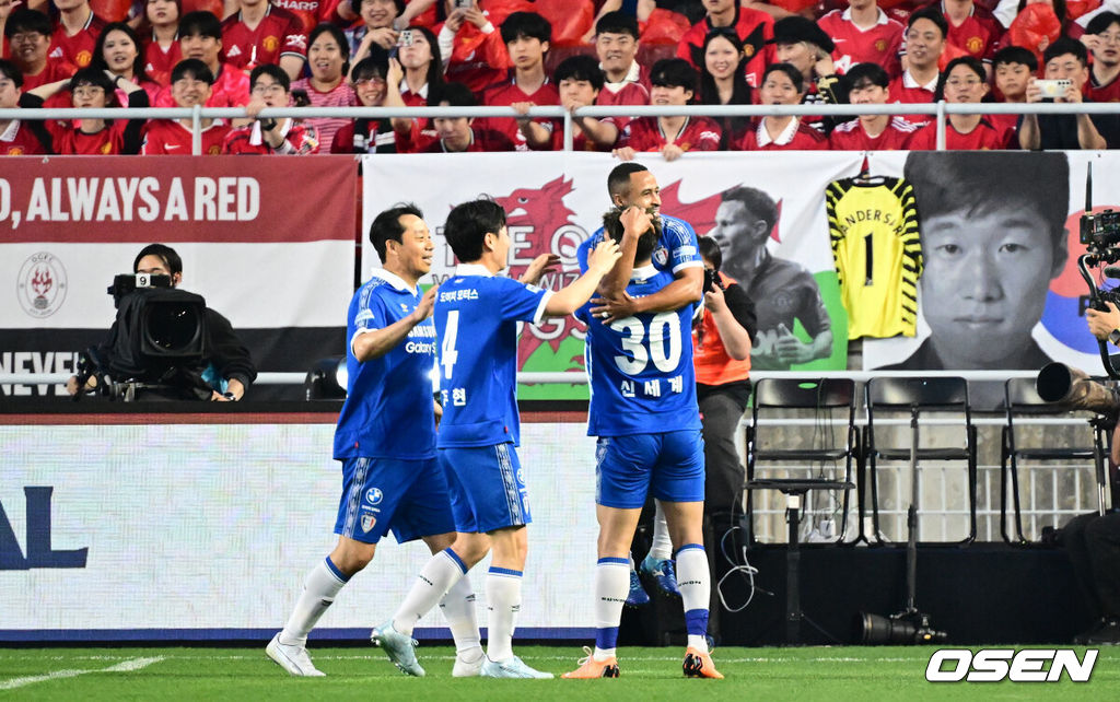 OGFC와 수원삼성 블루윙즈 레전드 매치 ‘OGFC: THE LEGENDS ARE BACK’이 19일 수원월드컵경기장에서 열렸다.OGFC는 박지성, 리오 퍼디난드, 라이언 긱스, 파트리스 에브라 등 프리미어리그 황금기를 대표하는 레전드들이 축구 콘텐츠·이벤트 제작사 슛포러브와 함께 결성한 신생 독립팀이다.수원삼성 산토스가 선제골을 넣은 뒤 신세계에게 안기고 있다. 2026.04.19 /cej@osen.co.kr