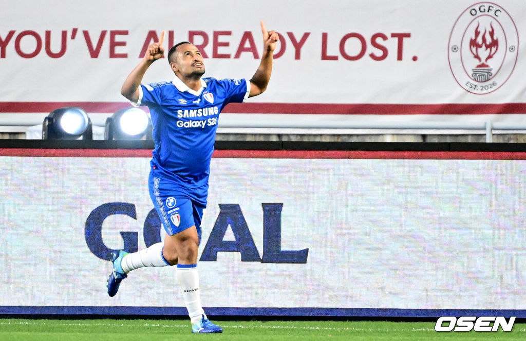 OGFC와 수원삼성 블루윙즈 레전드 매치 ‘OGFC: THE LEGENDS ARE BACK’이 19일 수원월드컵경기장에서 열렸다.OGFC는 박지성, 리오 퍼디난드, 라이언 긱스, 파트리스 에브라 등 프리미어리그 황금기를 대표하는 레전드들이 축구 콘텐츠·이벤트 제작사 슛포러브와 함께 결성한 신생 독립팀이다.수원삼성 산토스가 선제골을 넣은 뒤 세리머니를 하고 있다. 2026.04.19 /cej@osen.co.kr