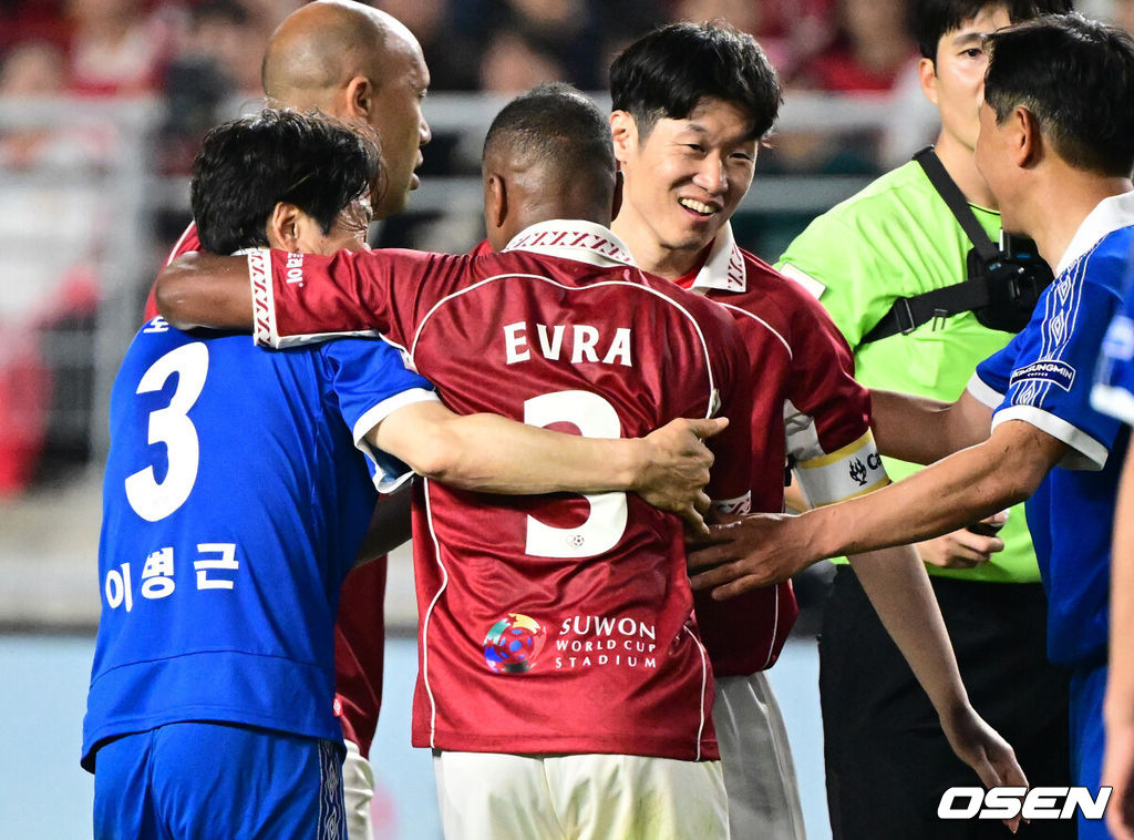 '해버지' 박지성(45)이 다시 수원월드컵경기장 잔디를 밟았다. 하지만 승자는 홈팬들의 웅장한 응원에 힘입은 수원 삼성 레전드 팀이었다.OGFC는 19일 오후 7시 수원월드컵경기장에서 수원 삼성 레전드 팀과 맞붙어 0-1로 패했다. 이번 경기는 박지성을 비롯해 프리미어리그 황금기를 이끌었던 전설들이 '슛포러브'와 함께 창단한 신생 독립 팀 OGFC가 닻을 올리는 첫 무대였지만, 총 38027명의 관중이 입장한 가운데 아쉬운 패배로 막을 내렸다.OGFC 에브라가 박지성에게 태클을 건 수원삼성 이병근에게 장난을 치고 있다. 2026.04.19 /cej@osen.co.kr