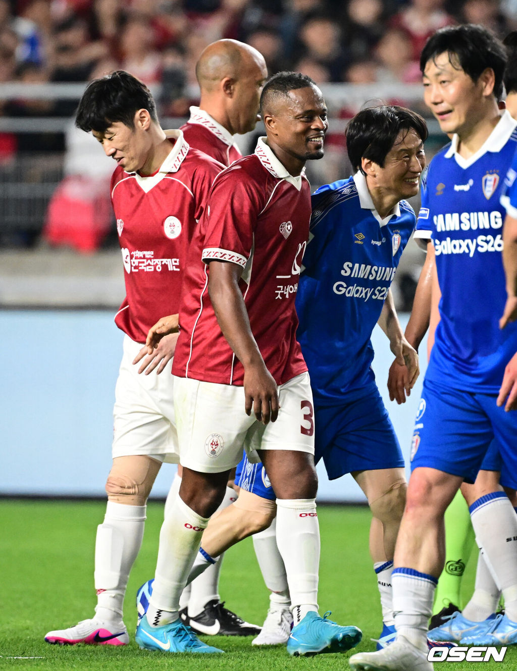 '해버지' 박지성(45)이 다시 수원월드컵경기장 잔디를 밟았다. 하지만 승자는 홈팬들의 웅장한 응원에 힘입은 수원 삼성 레전드 팀이었다.OGFC는 19일 오후 7시 수원월드컵경기장에서 수원 삼성 레전드 팀과 맞붙어 0-1로 패했다. 이번 경기는 박지성을 비롯해 프리미어리그 황금기를 이끌었던 전설들이 '슛포러브'와 함께 창단한 신생 독립 팀 OGFC가 닻을 올리는 첫 무대였지만, 총 38027명의 관중이 입장한 가운데 아쉬운 패배로 막을 내렸다.OGFC 에브라가 박지성에게 태클을 건 수원삼성 이병근에게 장난을 치고 있다. 2026.04.19 /cej@osen.co.kr