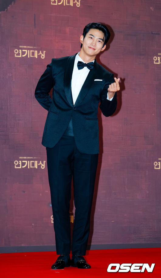 [OSEN=민경훈 기자] 31일 오후 서울 영등포구 여의도 KBS 신관 웨딩홀에서 2025 KBS 연기대상 레드카펫 포토월 행사가 열렸다.<br /><br />이날 오후 7시 10분 생방송으로 진행되는 ‘2025 KBS 연기대상’에서는 미니시리즈, 장편 드라마, 일일드라마 부문별 우수상과 최우수상을 비롯해 베스트 커플상, 인기상, 조연상, 신인상 등 시상이 진행된다.<br /><br />배우 옥택연이 무대 위에서 포즈를 취하고 있다. 2025.12.31 /rumi@osen.co.kr