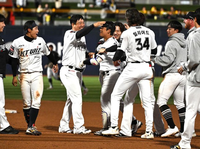 [OSEN=수원, 이대선 기자] 프로야구 KT 위즈가 LG 트윈스를 꺾고&nbsp;1~2위 빅매치에서 웃었다.KT는&nbsp;28일 수원 KT위즈파크에서 열린 2026 KBO리그 LG와 경기에서 연장 10회 6-5 끝내기 승리를 거뒀다.&nbsp; KT는 18승 8패로 1위 자리를 지켰고, LG는 16승 9패로 1.5경기 차이로 밀려났다.경기 종료 후 끝내기 안타를 친 KT 강민성이 동료들의 축하를 받고 있다. 2026.04.28 /sunday@osen.co.kr