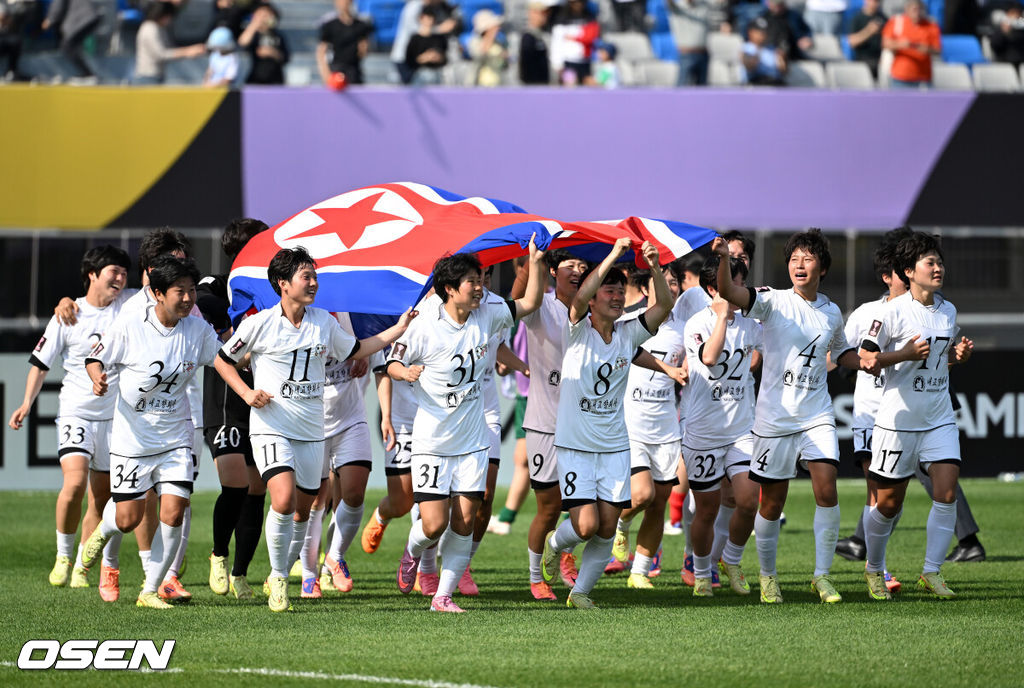 우승컵도, 100만 달러(약 15억 원) 우승 상금도 북한 내고향여자축구단 차지가 됐다. 논란 속 한국에서 열린 결승전에서 내고향은 일본 도쿄 베르디 벨레자를 꺾고 아시아 정상에 올랐다. 경기장 분위기 역시 마지막까지 씁쓸함을 남겼다.내고향은 23일 오후 수원종합운동장에서 열린 2025-2026 아시아축구연맹(AFC) 여자 챔피언스리그(AWCL) 결승전에서 도쿄 베르디를 1-0으로 꺾고 우승을 차지했다. 이날 공식 관중은 2670명이었다.경기 종료 후 내고향여자축구단 선수단이 인공기를 펼치고 기념촬영을 하고 있다. 2026.05.23 /sunday@osen.co.kr