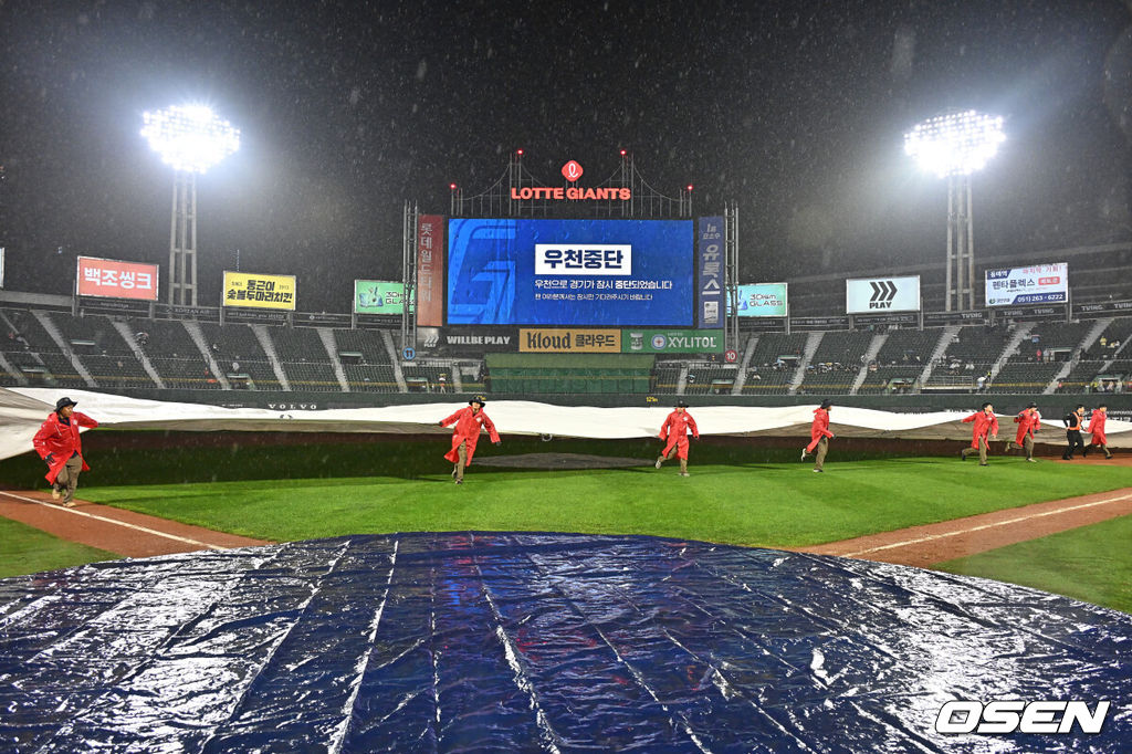 26일 부산 사직야구장에서 2026 신한 SOL KBO 리그 롯데 자이언츠와 LG 트윈스의 경기가 열렸다. 홈팀 롯데는 비슬리가, 방문팀 LG는 톨허스트가 선발 출전했다.관계자들이 많은 비가 내려 우천 중단된 경기장에 방수포를 덮고 있다. 2026.05.26 / foto0307@osen.co.kr