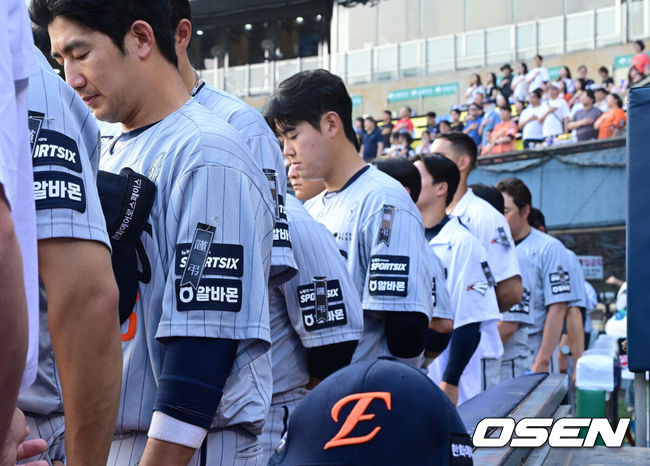[OSEN=잠실, 최규한 기자] 2일 서울 잠실야구장에서 ‘2026 신한 SOL Bank KBO리그’ 두산 베어스와 한화 이글스의 경기가 열렸다.홈팀 두산은 웨스 벤자민, 방문팀 한화는 박준영을 선발로 내세웠다.한화 선수단 및 코칭스태프가 한화에어로스페이스 폭발 사고로 유명을 달리한 임직원들을 추모하고 유가족에게 깊은 애도를 표하기 위해 유니폼에 근조 리본을 착용하고 경기에 나섰다. 경기를 앞두고 국기에 대한 경례를 하는 한화 선수단. 2026.06.02 / dreamer@osen.co.kr