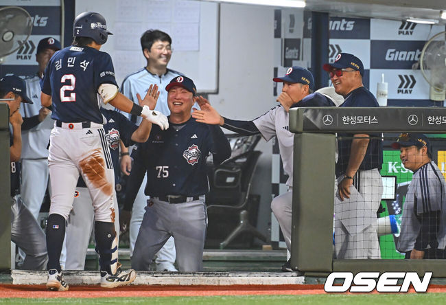 [OSEN=부산, 이석우 기자] 9일 부산 사직야구장에서 2026 신한 SOL KBO 리그 롯데 자이언츠와 두산 베어스의 경기가 열렸다. 홈팀 롯데는 나균안이, 방문팀 두산은 곽빈이 선발 출전했다.두산 베어스 김민석이 5회초 무사 1루 2루 땅볼을 치고 1루, 2루 송구 실책에 이어 3루에서도 송구 실책으로 볼이 빠지자 홈까지 쇄도, 득점을 올린 후 김원형 감독과 코치들의 축하를 받고 있다. 2026.06.09 / foto0307@osen.co.kr