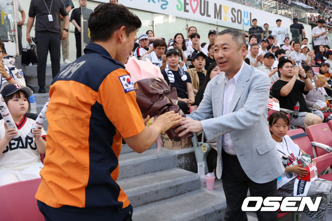 박정원 두산그룹 회장이 2024년 6월19일 '두산베어스 소방가족의 날'을 맞아 서울119 특수구조단 한정민 팀장에게 꽃다발을 건네고 있다.