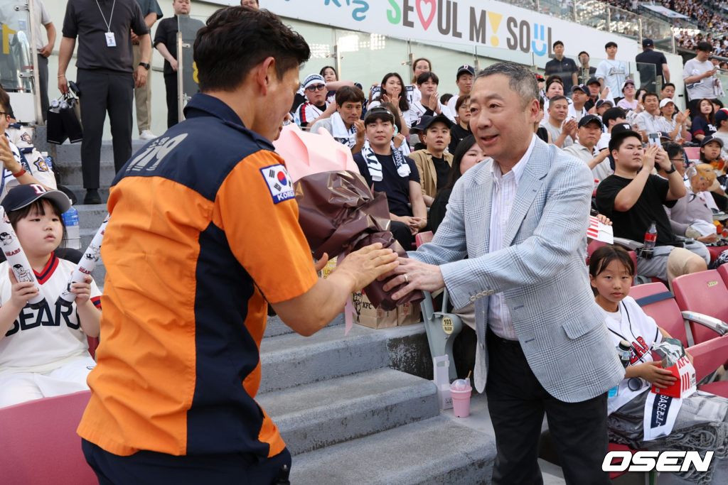 박정원 두산그룹 회장이 2024년 6월19일 '두산베어스 소방가족의 날'을 맞아 서울119 특수구조단 한정민 팀장에게 꽃다발을 건네고 있다. 