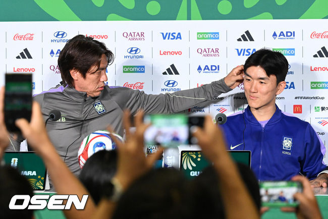 [OSEN=사포판(멕시코), 이대선 기자] 18일(한국시각) 멕시코 멕시코 과달라하라의 에스타디오 과달라하라에서 대한민국 축구국가대표팀 공식 기자회견이 진행됐다.대표팀은 19일 오전 10시(한국시간) 개최국 멕시코를 상대로 A조 조별리그 2차전을 갖는다.홍명보 감독이 황인범의 통역기 착용을 도와주고 있다. 2026.06.18 /sunday@osen.co.kr