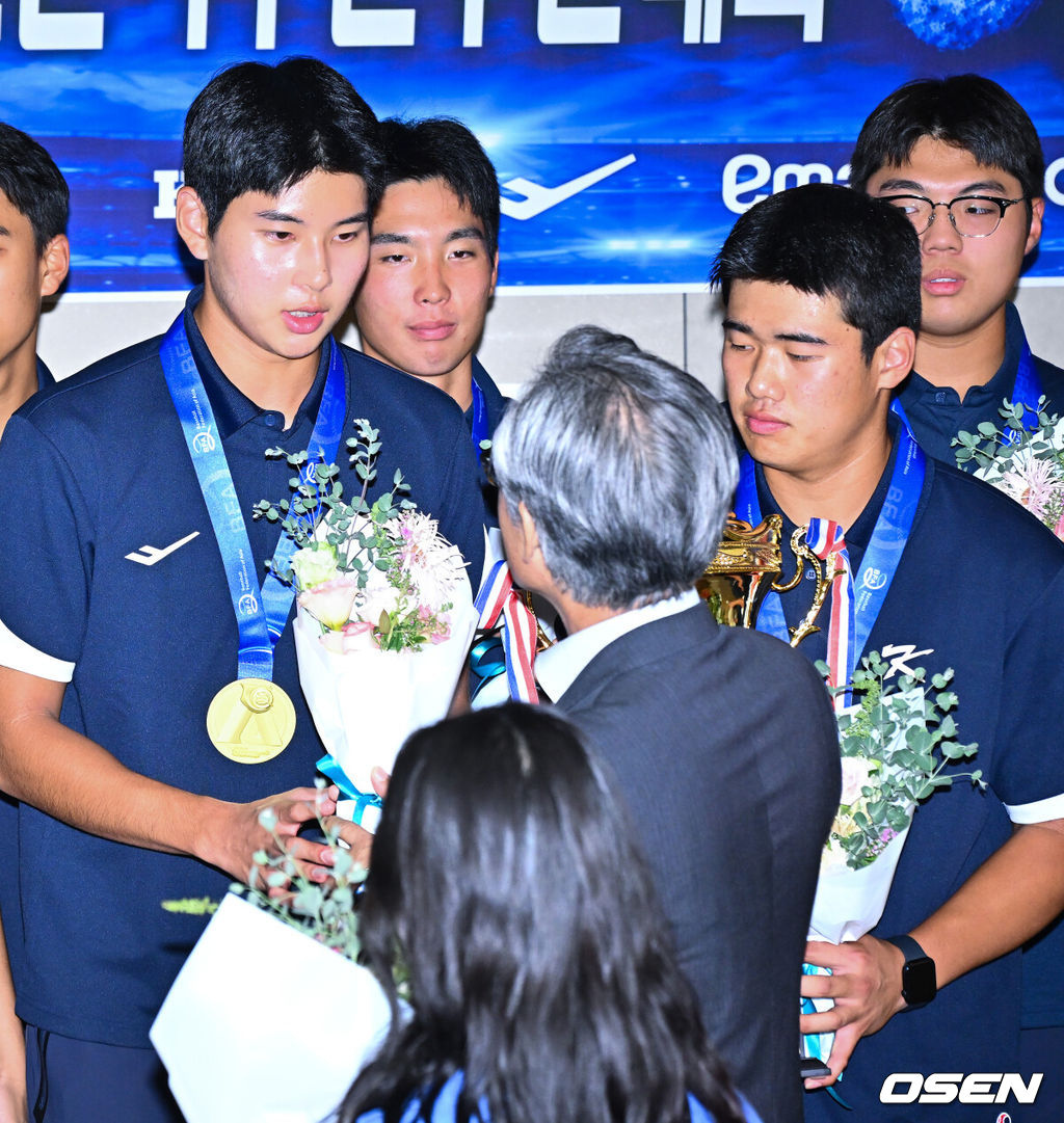  정윤진(덕수고) 감독이 이끄는 한국 18세 이하(U18) 야구대표팀이 14일 오후 인천국제공항을 통해 입국했다.U18 야구대표팀은 지난 13일 대만 타이베이돔에서 열린 제14회 아시아청소년야구선수권대회 결승전에서 일본을 2-0으로 제압, 8년 만이자 통산 6번째 우승을 차지했다.양해영 대한야구소프트볼협회장이 하현승, 엄준상에게 축하 꽃다발을 전달해주고 있다.   2026.09.14 / soul1014@osen.co.kr