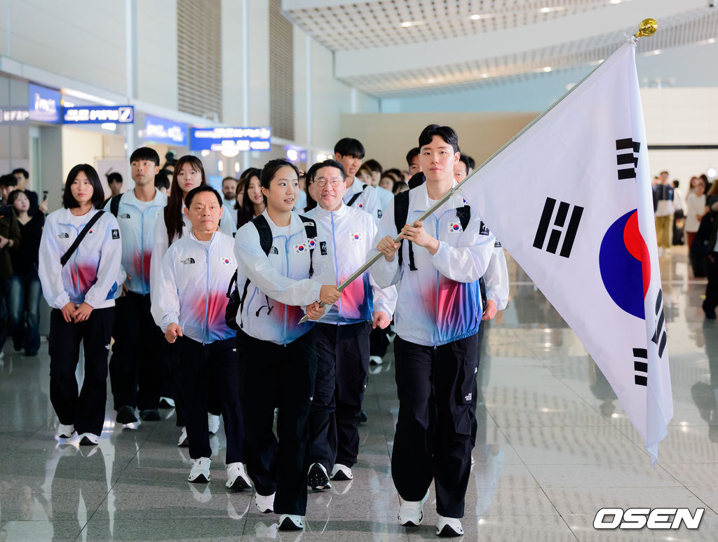 2026 아이치-나고야 아시안게임 대한민국 선수단 본단이 17일 오전 인천국제공항을 통해 일본으로 출국했다.아이치-나고야 아시안게임은 19일부터 10월 4일까지 일본 아이치현과 나고야시 일원에서 열린다. 대한민국은 41개 종목에 1,052명의 선수단을 파견한다. 선수 대표 탁구 신유빈, 배드민턴 서승재가 태극기를 들고 선수단과 함께 출국장으로 향하고 있다. 2026.09.17 / jpnews@osen.co.kr