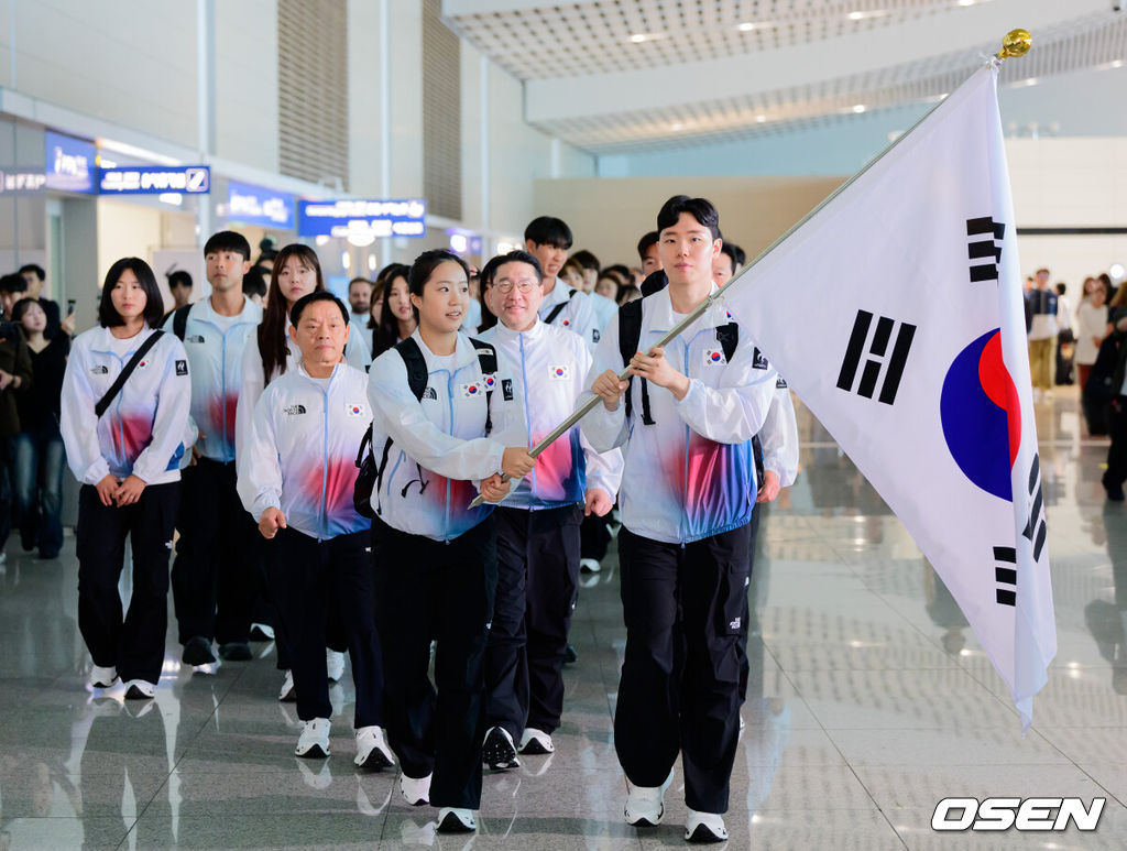 2026 아이치-나고야 아시안게임 대한민국 선수단 본단이 17일 오전 인천국제공항을 통해 일본으로 출국했다.아이치-나고야 아시안게임은 19일부터 10월 4일까지 일본 아이치현과 나고야시 일원에서 열린다. 대한민국은 41개 종목에 1,052명의 선수단을 파견한다. 선수 대표 탁구 신유빈, 배드민턴 서승재가 태극기를 들고 선수단과 함께 출국장으로 향하고 있다. 2026.09.17 / jpnews@osen.co.kr