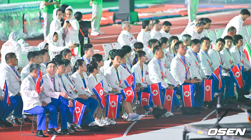 19일 일본 나고야 미즈호공원 육상경기장에서 제20회 일본 아이치·나고야 아시안게임 개막식이 진행됐다. 아이치·나고야 아시안게임 개회식에서 한국 선수단은 김동용·신유빈을 기수로 9개 종목 50명이 참가해 영문 국가명 순서에 따라 16번째로 입장한다. 아시안게임은 오는 10월 4일까지 열린다. 북한 선수단이 다른 선수단의 입장을 지켜보고 있다. 2026.09.19 / soul1014@osen.co.kr