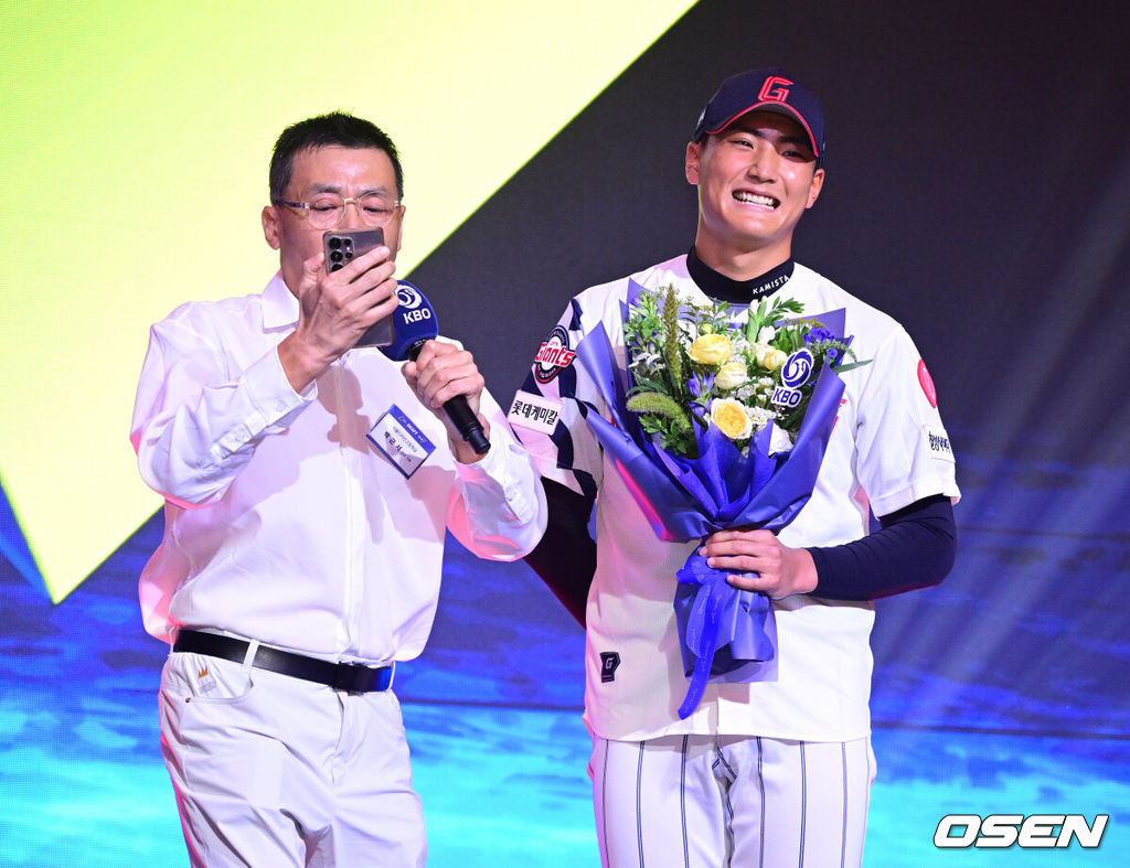 21일 오후 서울 잠실동 롯데호텔 월드 크리스탈볼룸에서 ‘2027 KBO 신인드래프트’가 열렸다. 이번 신인드래프트는 2025시즌 순위의 역순에 따라 키움 히어로즈, 두산 베어스, KIA 타이거즈, 롯데 자이언츠, KT 위즈, NC 다이노스, 삼성 라이온즈, SSG 랜더스, 한화 이글스, LG 트윈스 순서로 1라운드부터 11라운드까지 지명할 수 있다. 서울디자인고 박근서가 전체 4번으로 롯데 자이언츠에 지명된 뒤 아버지의 노래를 들으며 미소짓고 있다. 2026.09.21 / dreamer@osen.co.kr