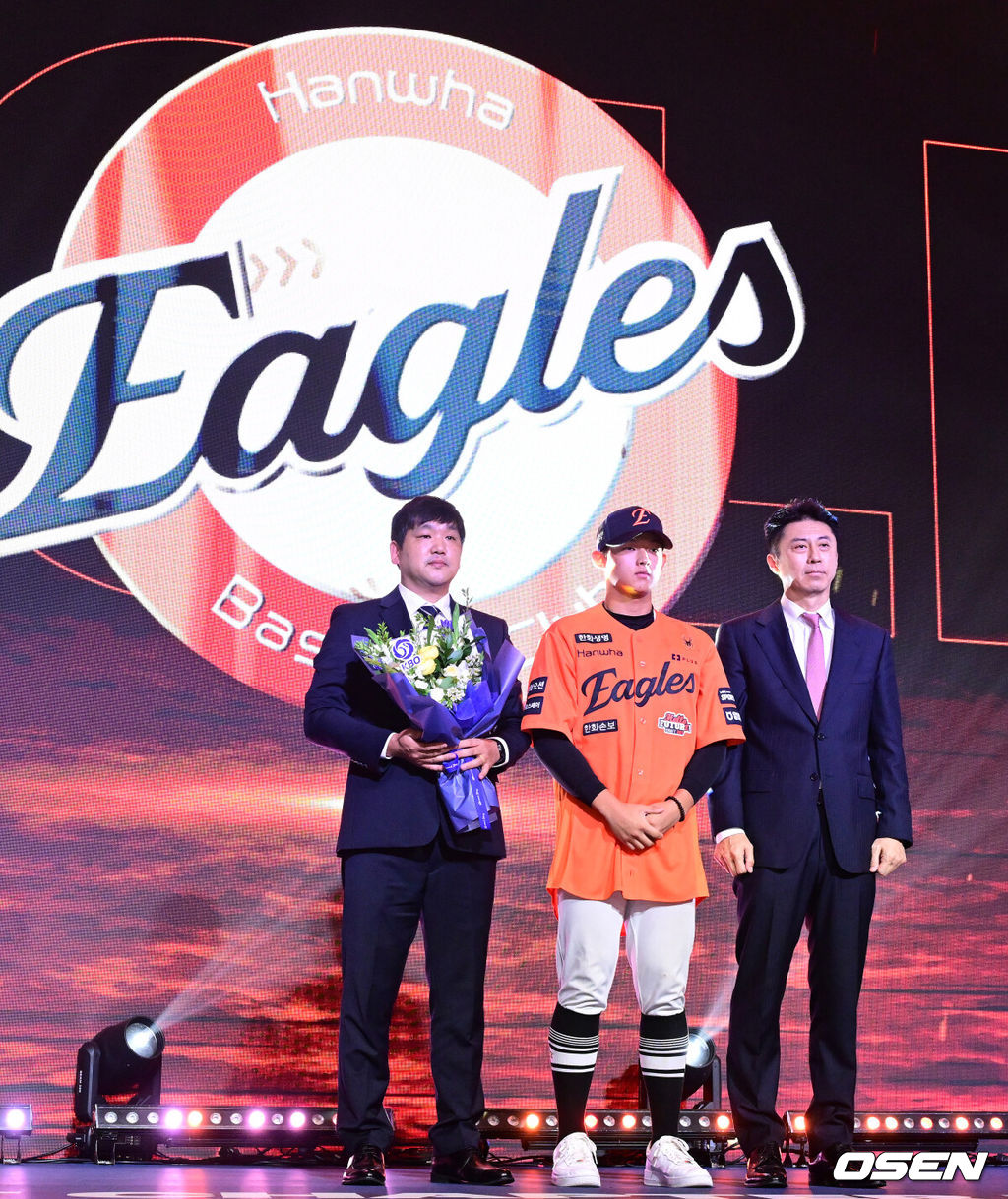 21일 오후 서울 잠실동 롯데호텔 월드 크리스탈볼룸에서 ‘2027 KBO 신인드래프트’가 열렸다. 이번 신인드래프트는 2025시즌 순위의 역순에 따라 키움 히어로즈, 두산 베어스, KIA 타이거즈, 롯데 자이언츠, KT 위즈, NC 다이노스, 삼성 라이온즈, SSG 랜더스, 한화 이글스, LG 트윈스 순서로 1라운드부터 11라운드까지 지명할 수 있다. 설악고 민주홍이 한화 1라운드에 지명된 뒤 손혁 단장과 기념촬영을 하고 있다. 2026.09.21 / dreamer@osen.co.kr