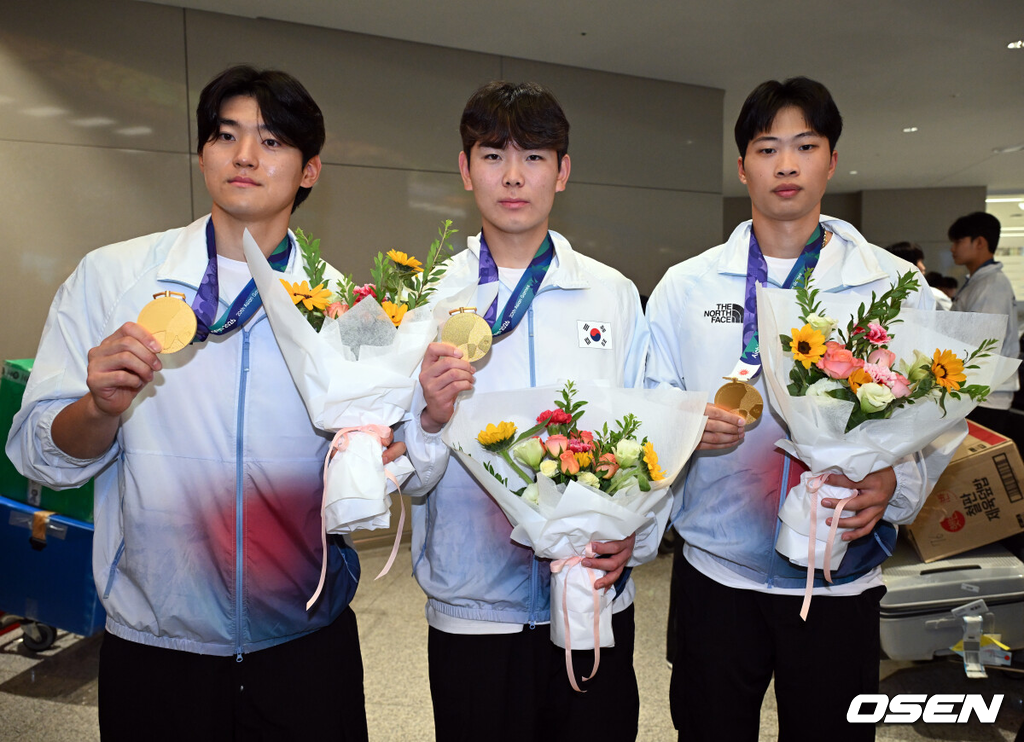 2026 아이치·나고야 아시안게임에서 금메달을 차지한 야구 대표팀이 28일 인천국제공항을 통해 귀국했다.한국 야구 대표팀은 금메달을 따내며 2010년 광저우 대회를 시작으로 2014년 인천, 2018년 자카르타-팔렘방, 2023년 항저우, 2026년 나고야-아이치까지 아시안게임 5회 연속 우승을 달성했다.야구대표팀 김도영, 성영탁, 박재현이 금메달을 들고 포즈를 취하고 있다. 2026.09.28 /cej@osen.co.kr