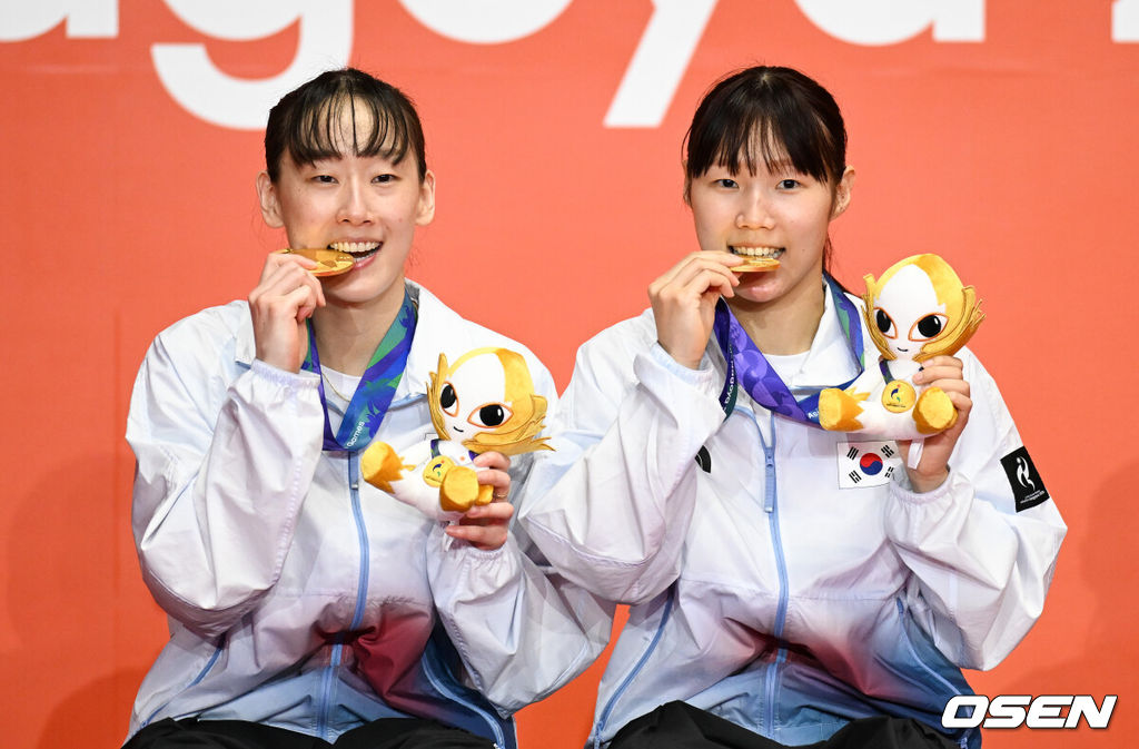 마침내 한국 배드민턴의 2026 아이치·나고야 아시안게임 첫 금메달이 탄생했다. 이소희-백하나(이상 인천국제공항) 조가 명승부 끝에 만리장성을 넘고 여자복식 정상에 올랐다. 배드민턴 여자 복식 세계 2위 이소희-백하나 조는 29일 일본 이치노미야 시립 체육관에서 열린 대회 여자 복식 결승전에서 중국의 류성수-탄닝 조(세계 1위)를 상대로 2-1(26-28 21-18 21-18)로 역전승을 거두며 우승했다. 1게임 41분, 2게임 28분, 3게임 37분으로 총 106분이 걸린 혈투였다.이소희-백하나가 금메달을 물고 포즈를 취하고 있다. 2026.09.29 / soul1014@osen.co.kr