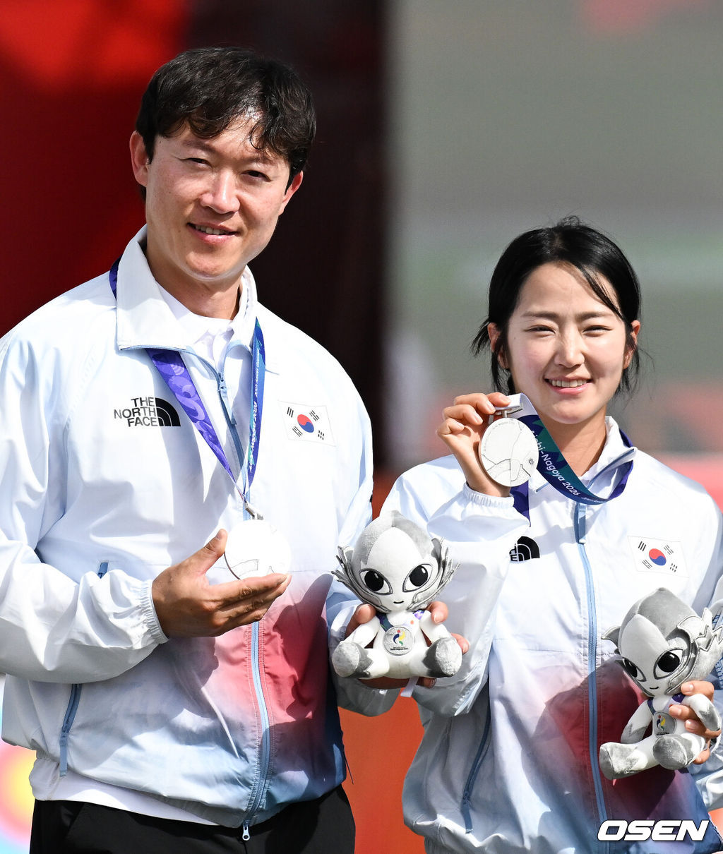 최용희-박정윤으로 구성된 한국 대표팀이 30일 일본 아이치현 오카자키 중앙종합공원 다목적광장에서 열린 2026 아이치·나고야 아시안게임 양궁 컴파운드 혼성 단체전 결승에서 인도의 타니파르티-자다브와 맞붙어 4엔드까지 157-157 동점을 기록했다.슛오프에서 승부가 갈렸다. 1점 차로 한국은 은메달을 목에 걸었다.시상식에서 최용희와 박정윤이 은메달을 들고 포즈를 취하고 있다.  2026.09.30 /  soul1014@osen.co.kr