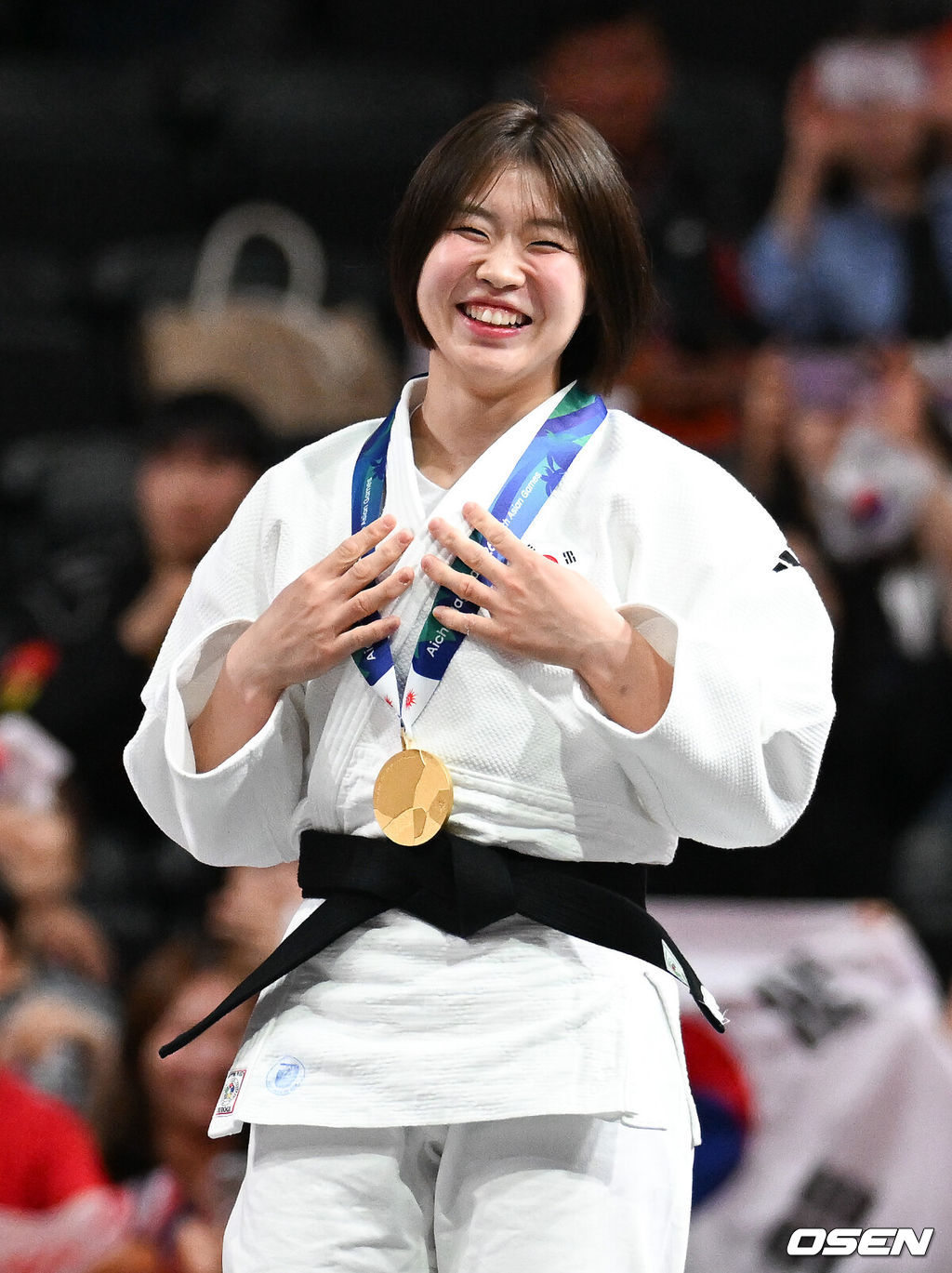 1일 일본 나고야 아이치 인터내셔널 아레나에서 2026년 아이치·나고야 아시안게임 유도 여자 57㎏급 결승 한국 허미미와 몽골 대표 테르비시 아리운자야의 경기가 진행됐다.허미미는 한국인 아버지와 일본인 어머니 사이에서 태어난 '재일교포'다. 복수국적자였지만, 2021년 '한국 선수로 뛰는 모습을 보고 싶다'는 할머니의 유언에 따라 한국 국적을 택했다.시상식에서 금메달 수상한 허미미가 미소 짓고 있다.  2026.10.01 / soul1014@osen.co.kr